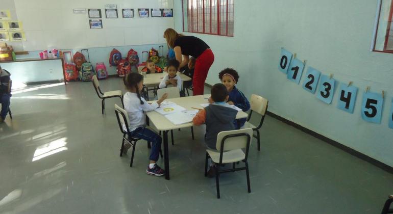 Crianças e professora em sala de aula