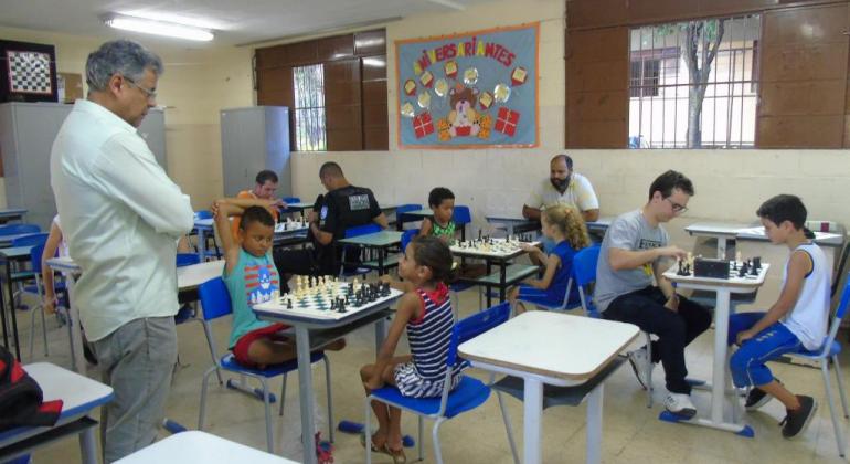 Foto de uma sala de aula em que o clube se reúne para jogar partidas de xadrez. crianças e adultos jogam juntos 