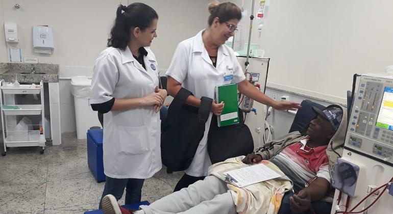 Paciente de hemodiálise acompanhado por uma técnica de saúde e uma professora. 