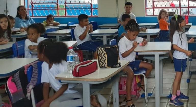 A Prefeitura vai ampliar, a partir do ano que vem, o horário de funcionamento das escolas infantis de tempo parcial e integral. Foto: Divulgação PBH Oito alunos, sentados em suas carteiras, em sala de aula.