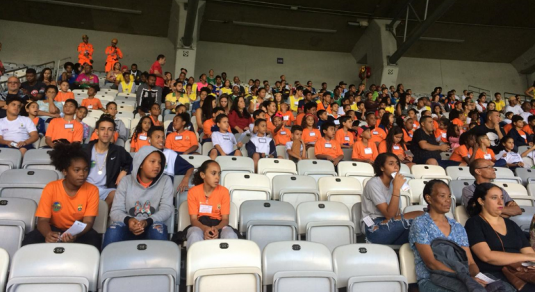Mais de 60 estudantes de escolas municipais, sentados nas cadeiras de arquibancada do Mineirão.