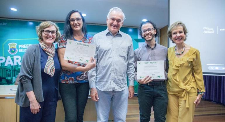 O reforço desse trabalho conjunto, que já vem sendo desenvolvido, foi formalizado por meio de uma portaria assinada na sexta-feira, dia 5/7. Foto: Divulgação PBH Os secretários municipais de Cultura e Educação e dois beneficiados pela integração dos setores com certificados, posando para foto.