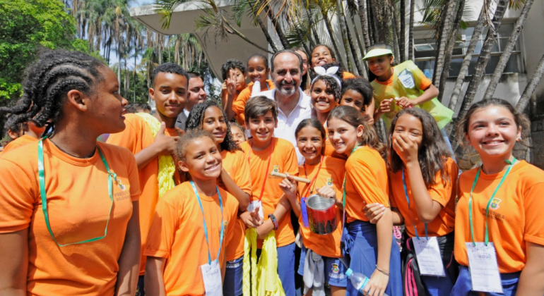 Prefeito Alexandre Kalil cencado de mais de quize estudantes com camiseta laranja, ao lado do Teatro Francisco Nunes, durante o dia. 