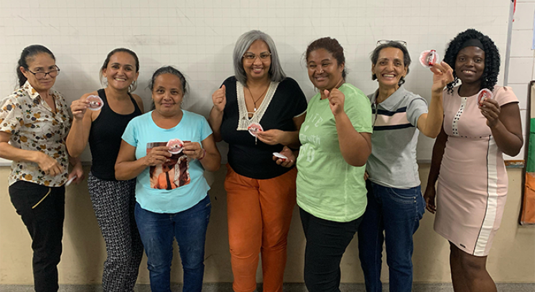 #paratodosverem: na foto, em uma sala de aula, sete mulheres estão em pé, em frente a um quadro branco, posando para a foto e sorrindo. 