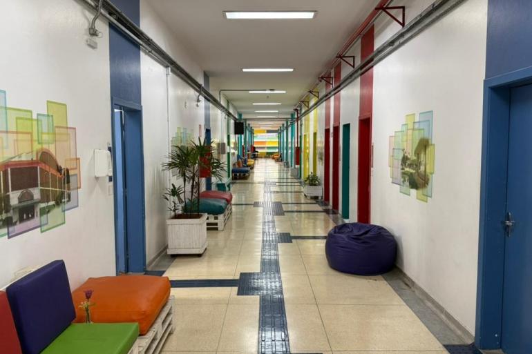 Sede do CAPE, na Secretaria Municipal de Educação Corredor colorido com pufes vermelhos, amarelo e azul