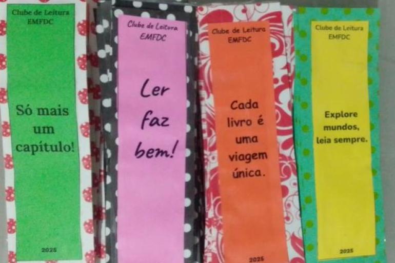 Estudantes avaliaram as atividades do Clube de Leitura como positivas #paratodosverem: Da esquerda para a direita, há quatro marcadores de página do “Clube de Leitura EMFDC”. O primeiro é verde e traz a frase “Só mais um capítulo!”. O segundo é rosa, com “Ler faz bem!”. O terceiro é laranja, com “Cada livro é uma viagem única.” O quarto é amarelo, com “Explore mundos, leia sempre.” Todos eles exibem o ano de 2025.