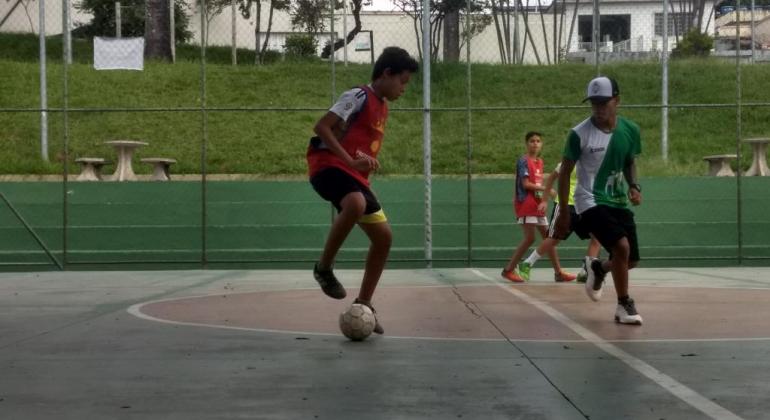 Prefeitura de Belo Horizonte, através do programa Esporte Esperança, oferece vagas em aulas de futsal masculino e feminino. Foto: Sara Lage/PBH Dois garotos jogam futsal.