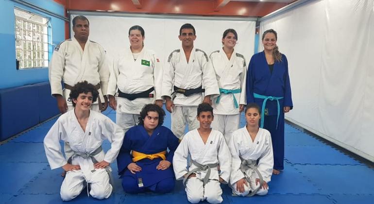 OIto integrantes da equipe de judô do Programa Superar posam para foto.