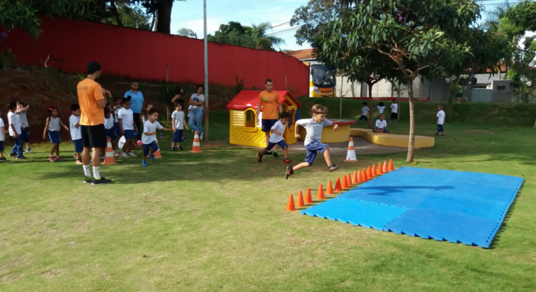 Crianças correm em gramado