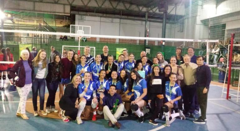 Jogos Escolares seguem com definição de novos campeões em modalidades coletivas Grupo de atletas de voleibol posam para foto com parentes, amigos e técnicos