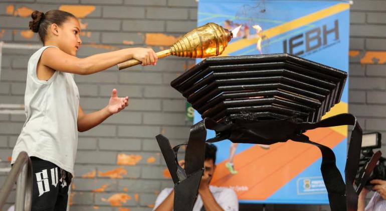Jogos Escolares de BH 2020 têm abertura suspensa e inscrições prorrogadas Criança acendendo a tocha dos Jogos Escolares