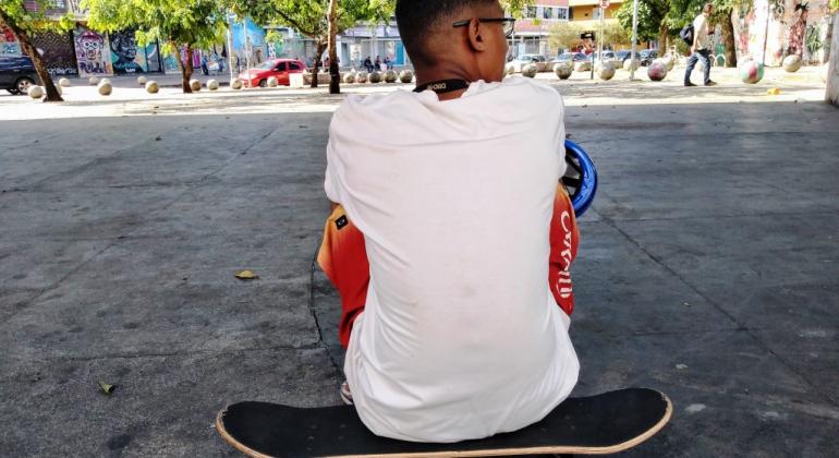 Jovem sentado em skate e que faz parte do Juventude em Movimento