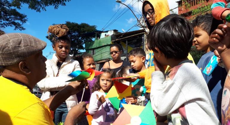 BH é da Gente de domingo, dia 28/7, tem ioga, show de talentos e dicas sobre cuidados com animais de estimação. Foto: Vilma Tomaz/PBH Homem mostra catavento a mais de dez crianças, durante o dia.