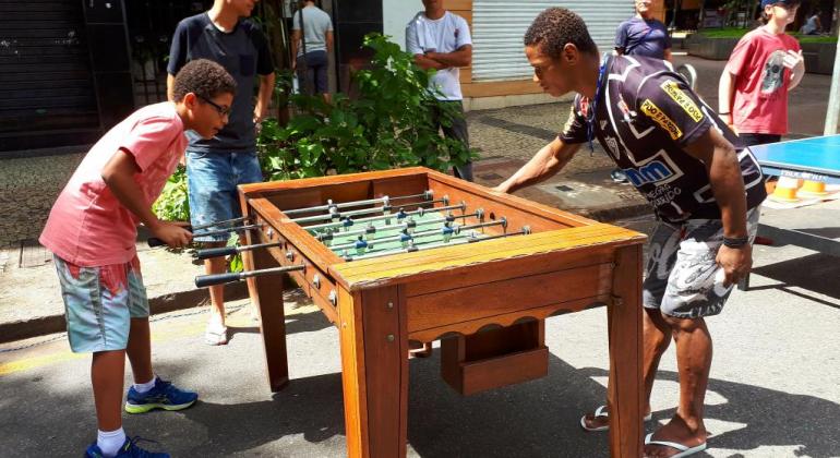 Oficinas recreativas e ações de saúde e combate ao trabalho infantil fazem parte do BH é da Gente. Foto: Vilma Tomaz/PBH Duas crianças jogam pebolim ao ar livre.