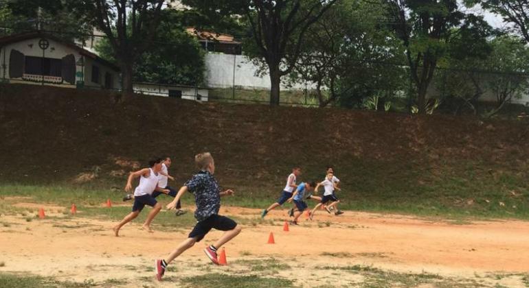 Esporte Esperança comemora Semana da Criança com Festival de Atletismo Seis crianças correm em campo de terra