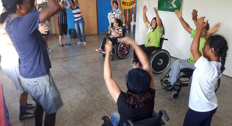 Alunos do Superar, alguns em cadeiras de roda, pessoas com deficiências diversas, ensaiam coreografia em salão para integrar ala de bloco de carnaval