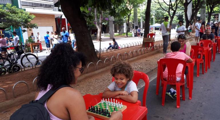 Crianças jogam xadrez em mesas de plástico ao longo da avenida, em edição do BH é da Gente - Savassi. 