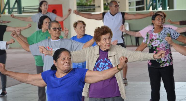 Mais de oito idosos fazendo aulas de Lian Gong como parte do programa Vida ativa. 