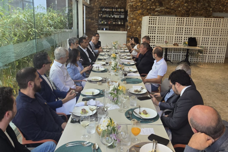 Presidente da Embratur, Bruno Reis, o procurador Geral do Município, Flávio Freire e o presidente da Belotur, Eduardo Cruvinel, sentados a mesa almoçando. 