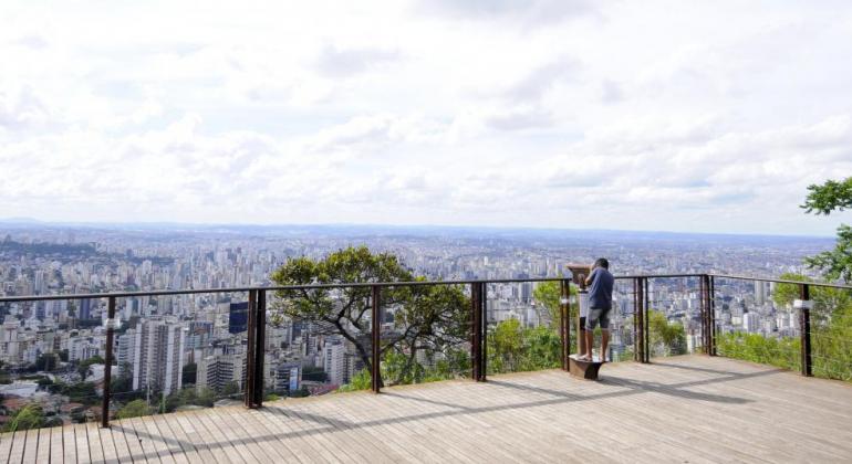 O Mirante do Mangabeiras agora terá seu horário de funcionamento estendido e ficará aberto ao público até às 20h. Mirante do Mangabeiras, durante o dia, com homem olhando a luneta.