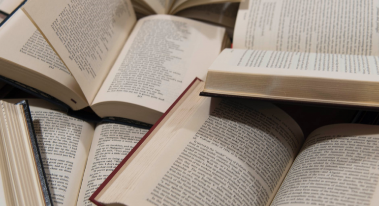 Os prêmios Cidade de Belo Horizonte, o mais antigo do país, e o João de Barro, voltado para jovens e crianças, estão com inscrições abertas. Foto: Amanda George/Pexels Seis livros, abertos, uns sobre os outros.