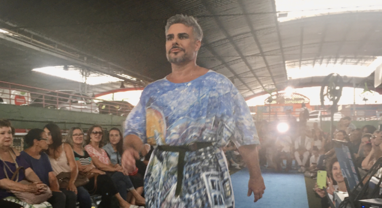 Homem com bata colorida desfila no Mercado Central. 