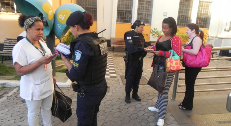 Servidoras do Hospital Odilon Behrens recebem apitos e cartilhas da campanha contra o assédio sexual no transporte público. Foto: Divulgação PBH Duas guardas municipais entregam folhetos educativos a funcionárias do Hospital Odilon Behrens.