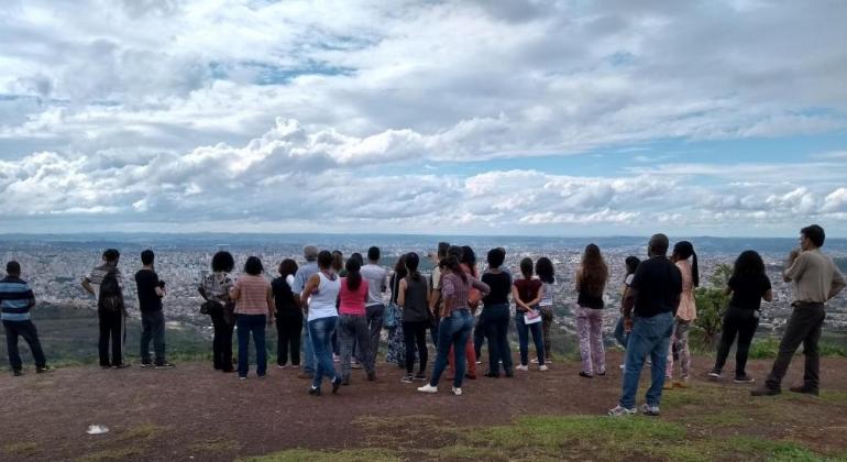 Mais de 20 agentes ambientais em formação contemplam a cidade de Belo Horizonte de ponto privilegiado, durante o dia. 