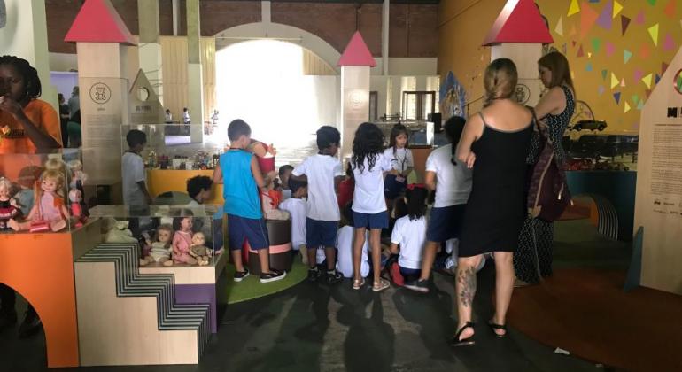 Mais de sete crianças acompanhadas de dois adultos na exposição “Tempo Será – Histórias e Memórias do Brincar", em cartaz no Centro Cultural Nordeste.