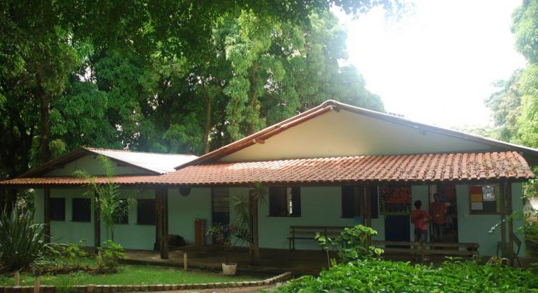 Duas casas de atendimento da Fazendinha, árvores e plantas.