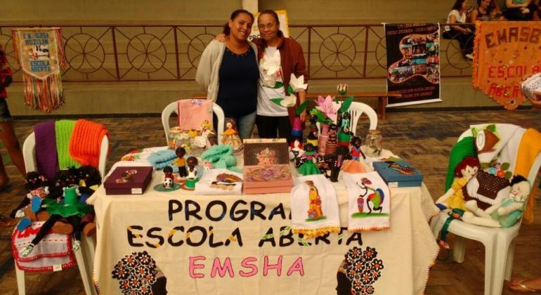 duas mulheres apresentam peças de artesanato no Programa Escola Aberta