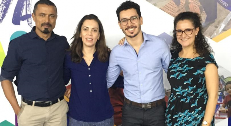 Realizado no dia 8 de julho, evento teve por finalidade fortalecer as ações de prosperidade urbana sustentável e inclusiva. Foto: Divulgação PBH O gerente de Indicadores da Secretaria Municipal de Planejamento, Orçamento e Gestão, Rodrigo Nunes Ferreira, acompanhado de duas mulheres e um homem.