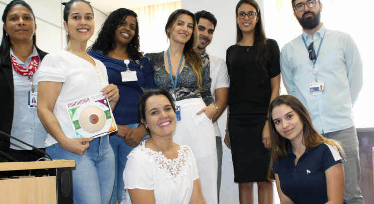 A PBH, em parceria com a Unimed-BH, promove, até o dia 25/10, atividades em diversos órgãos municipais, conferidos neste link. Foto: Divulgação PBH Oito pessoas, uma delas com um seio artificial - parte da campanha Outubro Rosa - nas mãos, posam para a foto.
