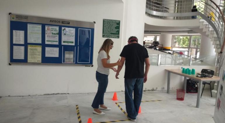 Técnica da saúde auxiliando sevirdor a percorrer uma linha pontilhada em ziguezague