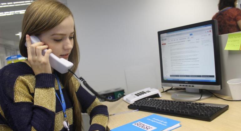 Prefeitura abre 114 vagas de estágio na área da Saúde para estudantes do nível médio Estagiária fala ao telefone