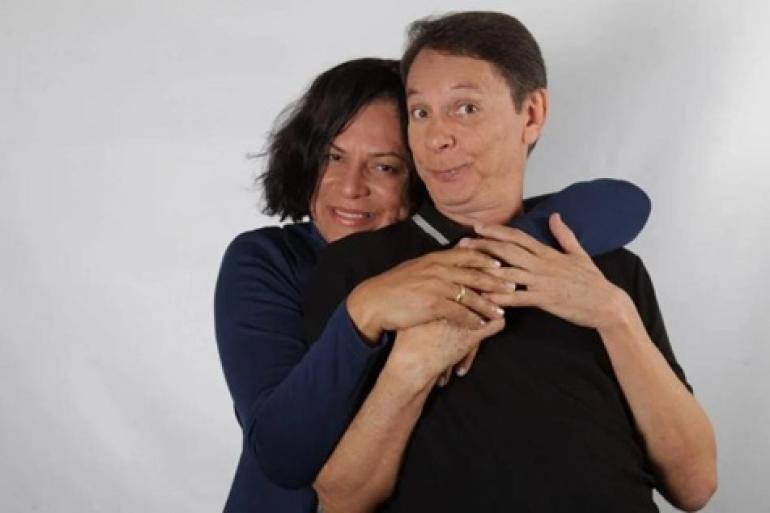 Carlos Nunes e Kayete percorrem diferentes épocas em comédia no Teatro Francisco Nunes Duas pessoas abraçadas contra um fundo branco e liso. Uma mulher de cabelo escuro pelos ombros está atrás, sorrindo e a apoiar a cabeça no ombro de um homem. Ela envolve os braços ao redor do peito dele. O homem, à frente, veste uma blusa preta e faz uma expressão facial divertida e cômica, com os olhos arregalados e as sobrancelhas levantadas, enquanto segura as mãos dela.