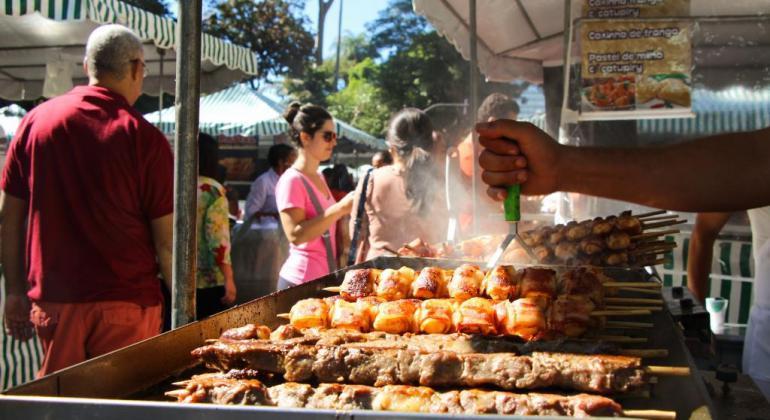 Barracas de feiras de artesanato e de comidas e bebidas típicas em que são servidos espetinhos.