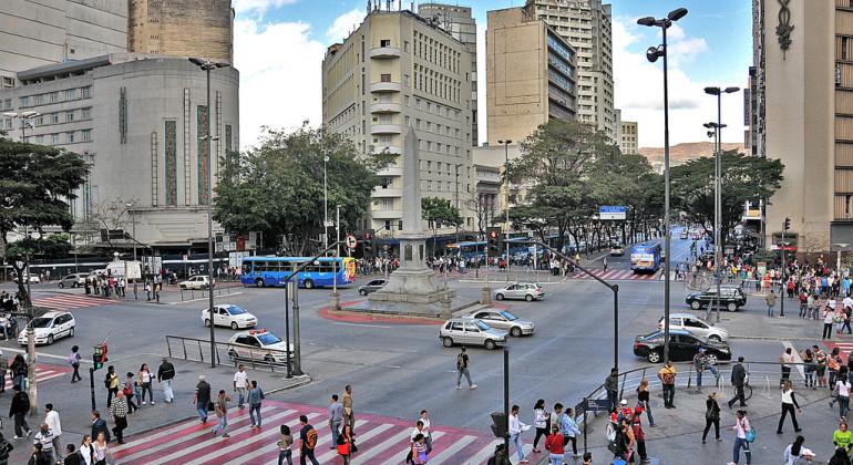 Praça Sete, durante o dia, com movimento de pessoas e carros. 