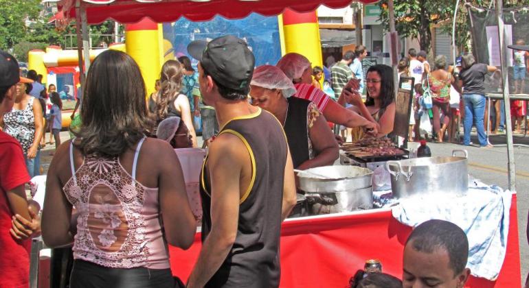 Casal em frente a uma barraca de tração de churrasquinhos