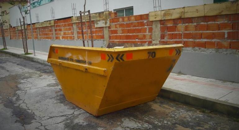 A Lei 11.212/20 altera o Código de Posturas e determina apreensão do equipamento e aplicação imediata de multa à empresa ou quem a contratou. Foto: Divulgação PBH Caçamba na margem da rua, durante o dia.