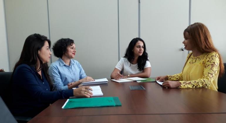 Foto: Acyr Bemfica/PBH Quatro mulheres sentadas à mesa, interagindo entre si.