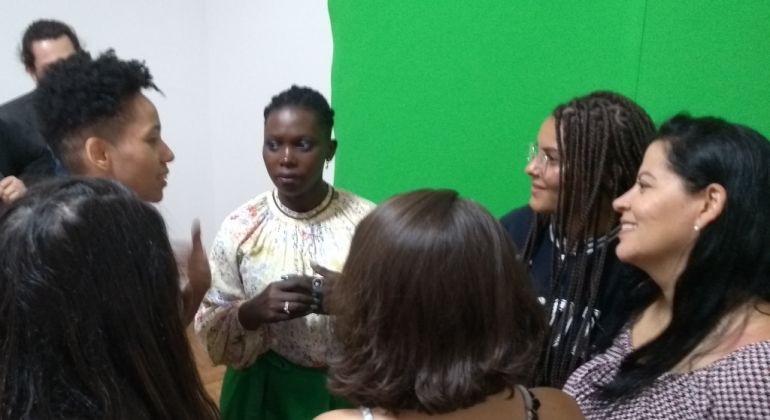 A ativista Mariéme Jamme conheceu, no dia 21/11, o projeto Programando Sonhos Delas, que inclui mulheres no mercado da programação. Foto: Divulgação PBH Ativista senegalesa em meio a seis jovens, todos de pé.