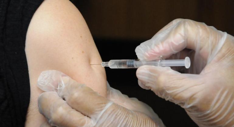 Pessoa sendo vacinada no braço esquerdo