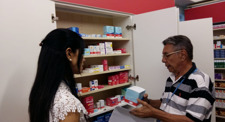 Secretaria Municipal de Saúde iniciou na segunda, dia 19 /11, ação de conscientização sobre a prescrição e uso racional de antibióticos. Foto: Karen Moreira/PBH Homem segura antibiótico em frente a armário de medicamentos, ao lado de mulher.