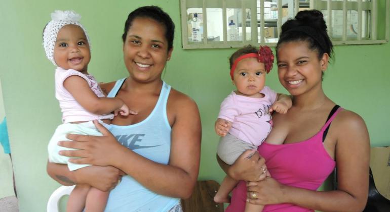 Jéssica Duque com a filha Lara Valentina e Clarice Pontes com a filha Luna Beatriz. Foto: Andréa Moreira Duas mulheres com suas filhas nenéns no colo.
