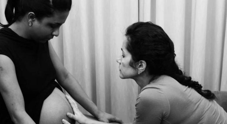 Parto humanizado. Foto: Micheline Souza/PBH Doula voluntária com as mãos na barriga de uma gestante
