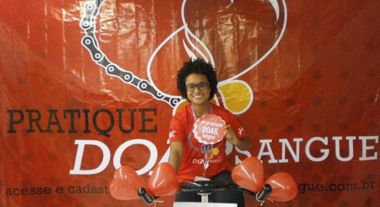 Servidora da Prefeitura de Belo Horizonte com camisa e balões vermelhos