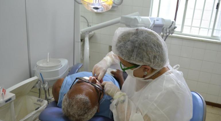 Trabalho desenvolvido pela Prefeitura de Belo Horizonte oferece acompanhamento odontológico e próteses gratuitas para idosos. Foto: Kátia Gaspar/PBH Dentista confere boca de isoso em consultório;