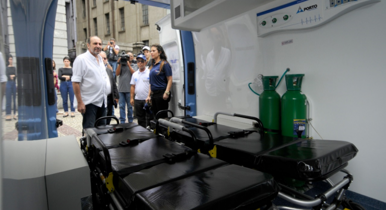 Na segunda-feira, dia 25/11, a Prefeitura entregou 28 veículos de médio porte e 11 de grande porte para para o Transporte de Saúde em BH. Foto: Amira Hissa/PBH Prefeito Alexandre Kalil, com imprensa ao fundo observa interior de ambulância doada para a saúde de BH.
