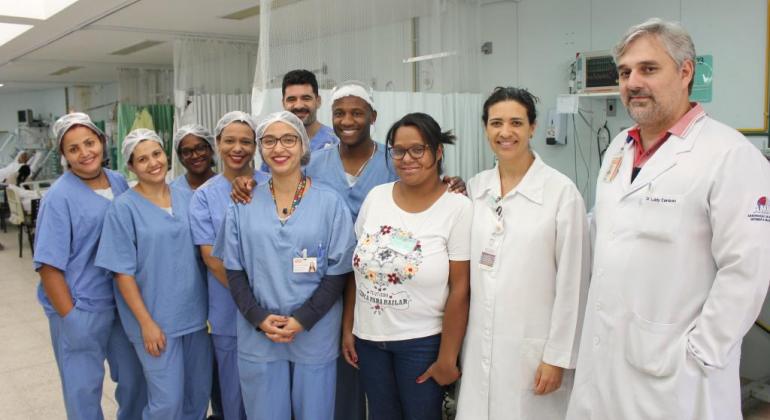Sete enfermeiros, uma paciente e dois médicos em ambiente hospitalar do Hospital Metropolitano Odilon Behrens. 